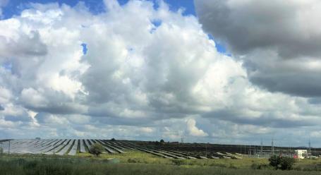 Rows of solar panels in a large solar park on a sunny day in India.